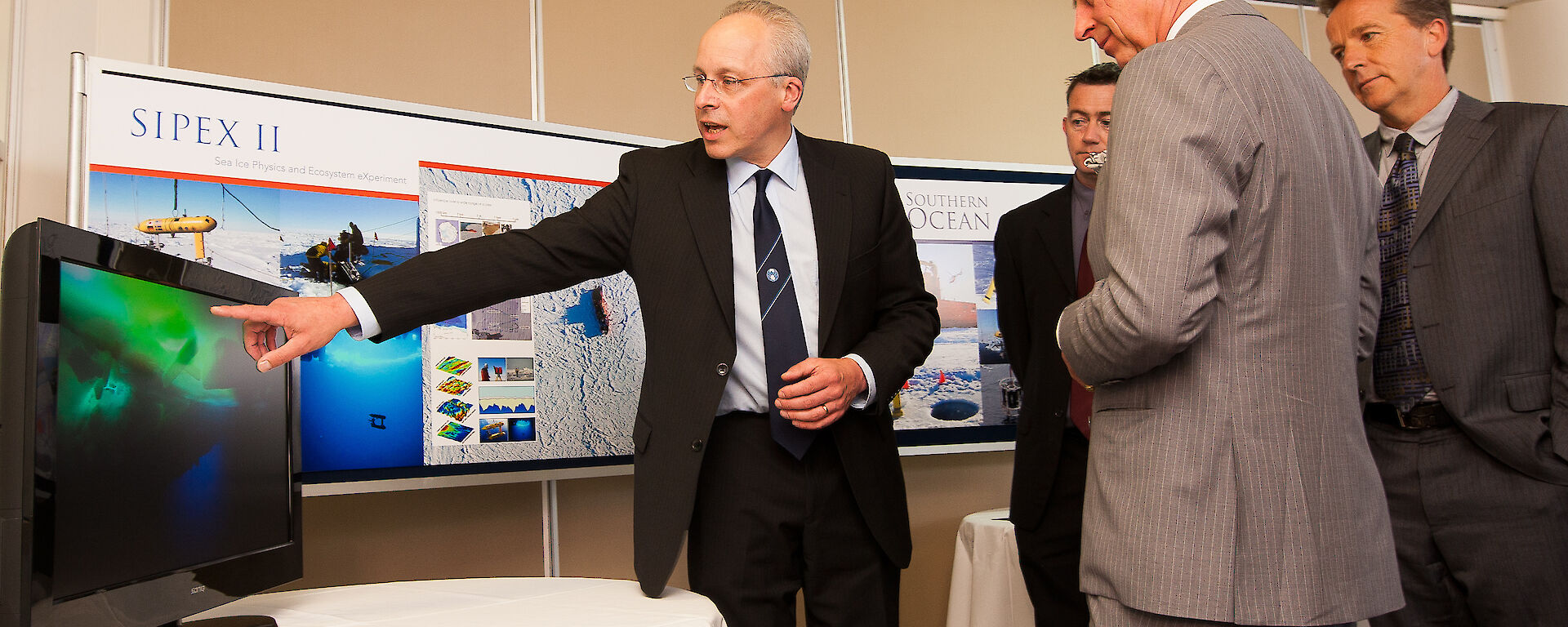 Dr Van Ommen pointing to a screen while the Prince watches on