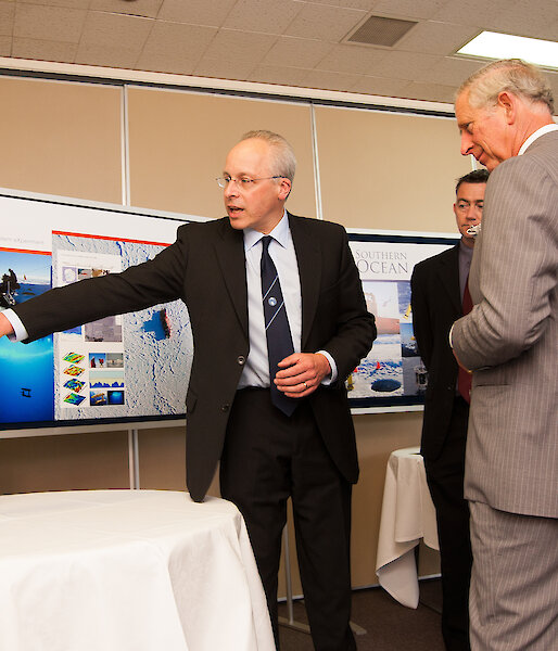 Dr Van Ommen pointing to a screen while the Prince watches on