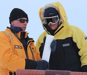 Minister and glaciologist looking at an ice core