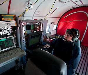 Scientist Veit Helm in front of the radar altimeter instrumentation rack in the Polar-6.