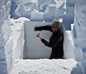 A scientist takes snow and ice samples in a snow pit.