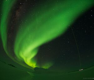 The green laser of the Davis lidar is visible during an aurora australis display.