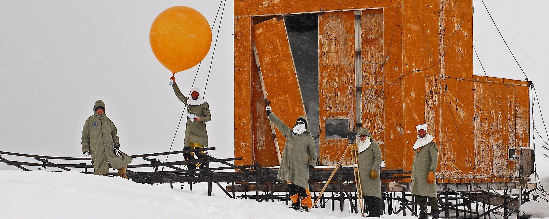 Expeditioners prepare to release a weather balloon in front of the old balloon shed at Wilkes.