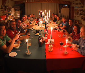 Expeditioners around the dinner table, by candlelight