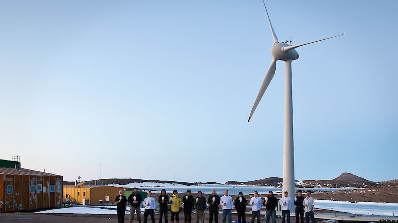 Expeditioners in standing in front of the wind turbine at Mawson