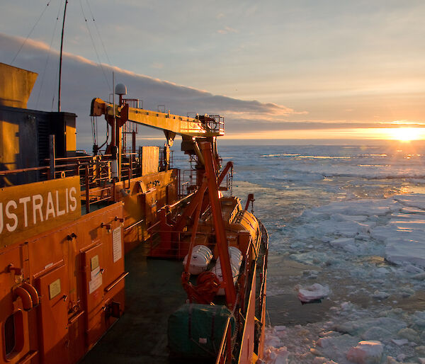 Aurora Australis in the ice, with sunset in the background