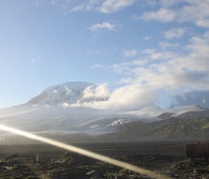 Light cloud around a snowy peak.