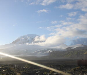 Light cloud around a snowy peak.