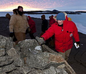 The Mawson station winterers place rocks on the cairn holding Dr Phillip and Nellie Law’s ashes.