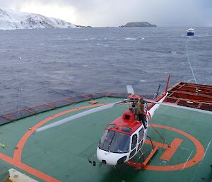 A helicopter returns to the Aurora Australis from Macquarie Island