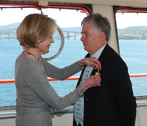 Governor-General pinning medal on Dr Nicol