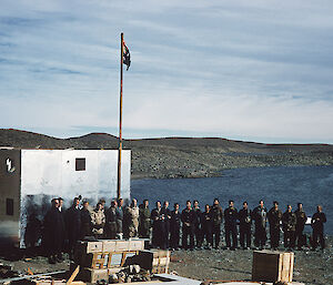 Group of men posing beside flag and buildings at Davis