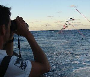 Man watching longline behind boat