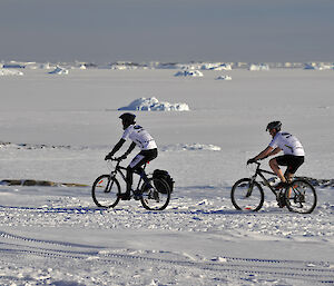 Two lycra-clad expeditioners riding bikes in Antarctica