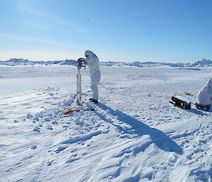 Casey expeditioner drilling for sea ice cores