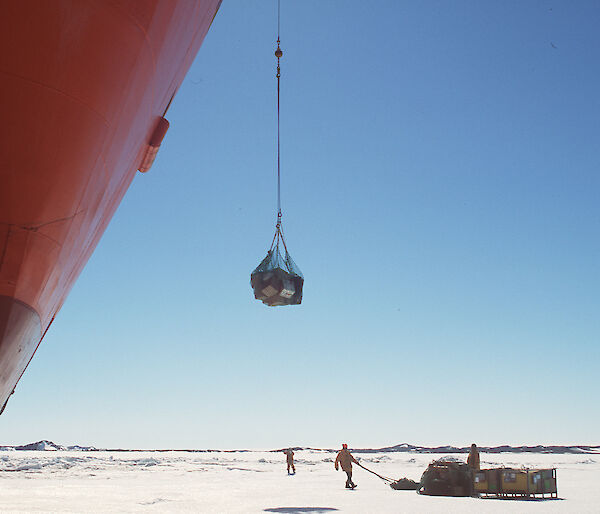 A crane on the Aurora Australia uploads cargo from the ice onto the ship