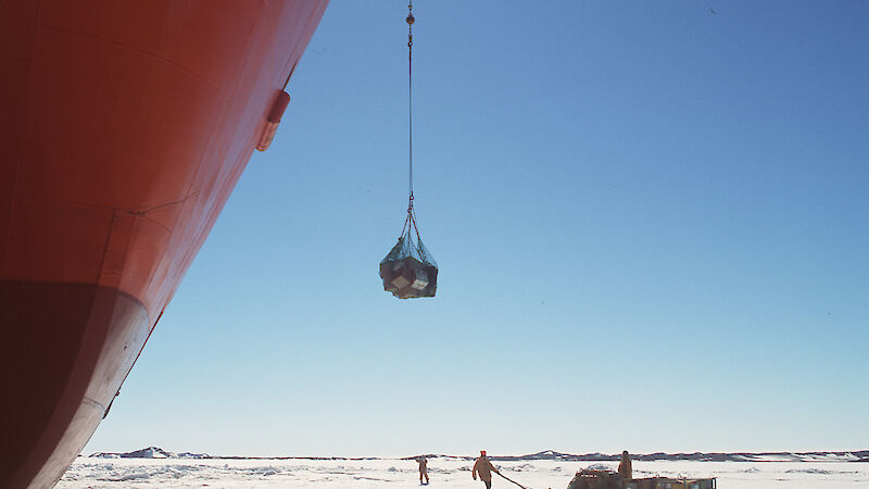A crane on the Aurora Australia uploads cargo from the ice onto the ship