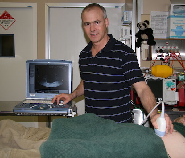 Mawson station Doctor Glenn Browning using the ultrasound on a patient