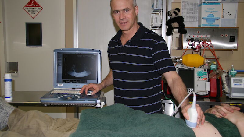 Mawson station Doctor Glenn Browning using the ultrasound on a patient