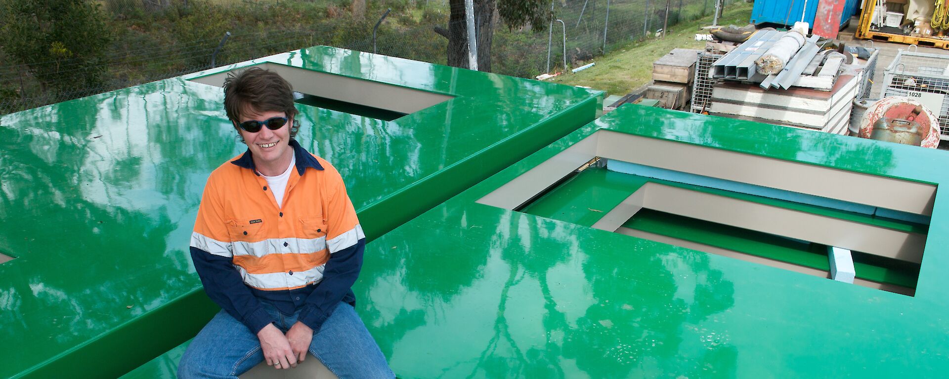 Project Engineer Mark Pekin sitting on some of the finished panels ready to be shipped to Antarctica