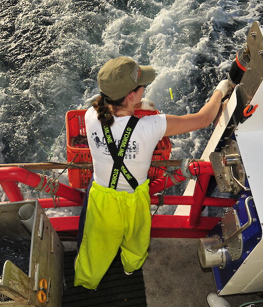 The Underwater Bait Launcher being used by fisher on the back of a boat