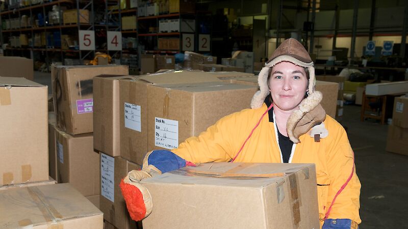 Warehouse and Distribution Supervisor, Amber Martyn, holds a box of donated clothing