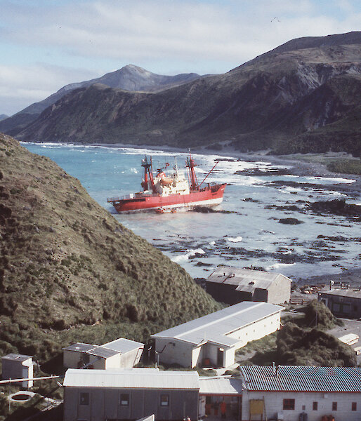 Grounded ship, the Nella Dan, up on rocks near Macquarie Island station buildings