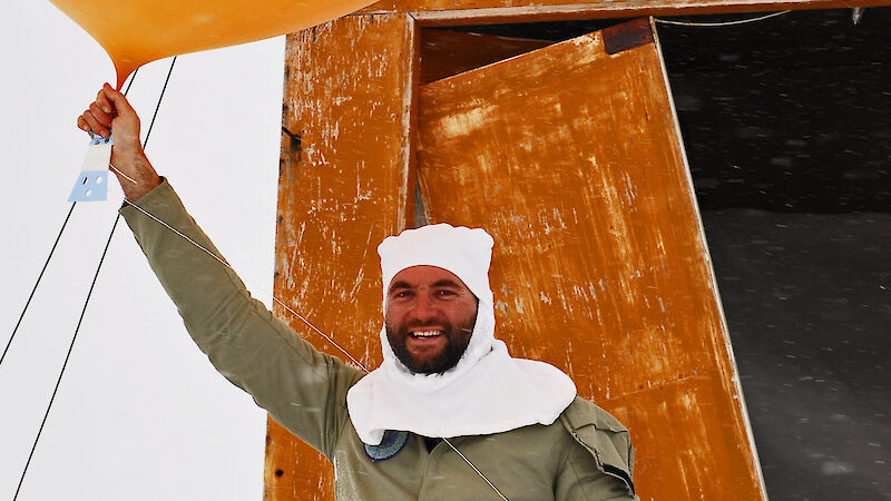 Weather observer holding helium-filled weather balloon