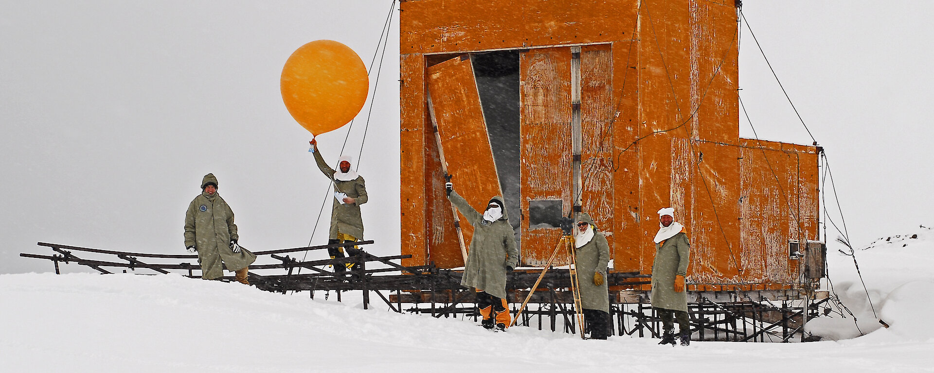 Expeditioners prepare to release a weather balloon on front of the old balloon shed at Wilkes