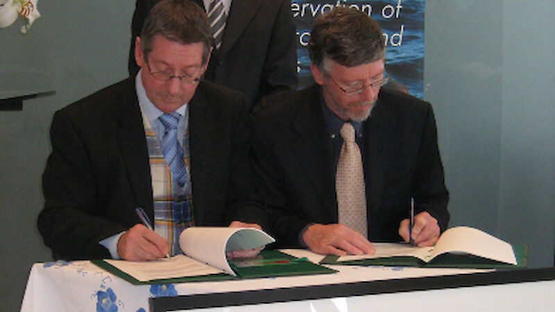 Dr Tony Press, Director of the AAD, and Warren Papworth, ACAP Executive Secretary, sign the headquarters agreement (Director of Antarctic Tasmania, Ben Galbraith standing)