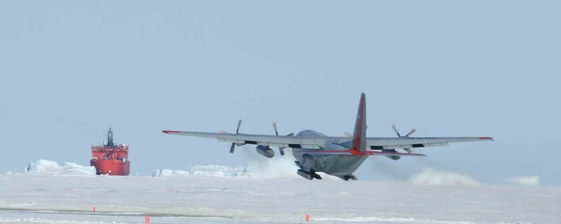 US C-130 Hercules aircraft lifting off from sea-ice runway at Davis station with injured expeditioner Dwayne Rooke on board. Aurora Australis in the background.