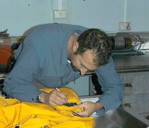 Man removing seeds and other propagules from clothing prior to arrival in Antarctica