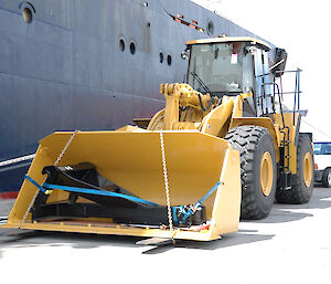 Multi-purpose loader machine next to ship