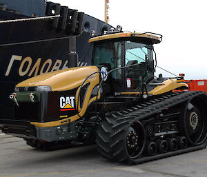 Rubber-tracked tractor next to ship