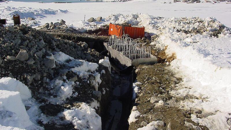 A permeable reactive barrier in the trench, directing contaminated water from the site.