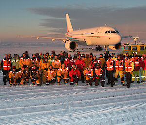 A group of people standing in front of a plane.