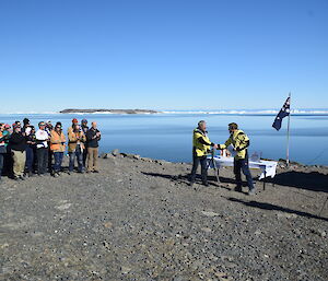 Group of people standing in front of water.