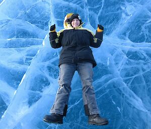 Station Supply Officer, Jen Proudfoot, lying on a frozen freshwater lake, in the Vestfold Hills near Australia’s Davis research station