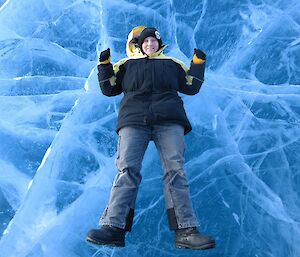 Station Supply Officer, Jen Proudfoot, lying on a frozen freshwater lake, in the Vestfold Hills near Australia’s Davis research station