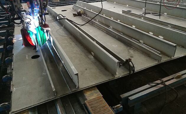 Structural steel bars or stiffeners being welded on to plate steel.
