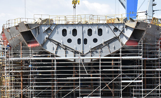 The bow of the ship with ‘anchor pockets’ (recesses to house the anchors) visible on each side of the ship.