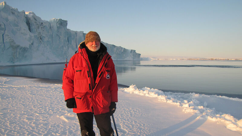 Man standing on ice in red jacket