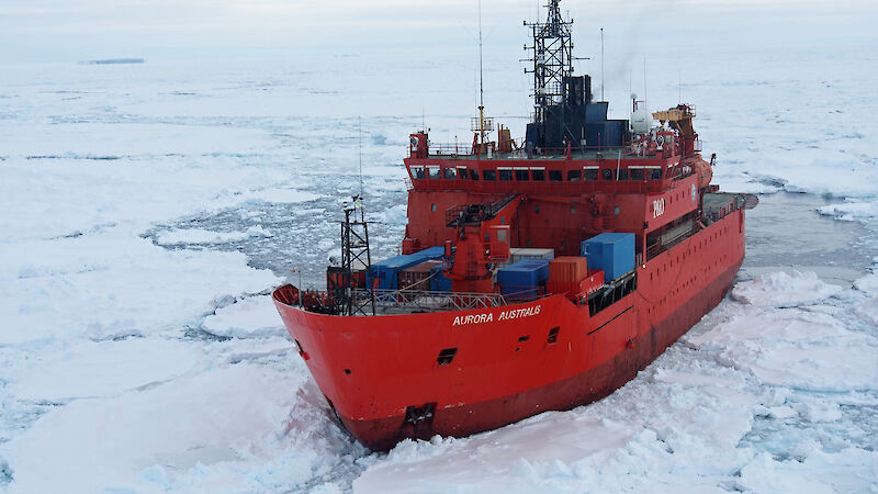 Aerial view of the ship Aurora Australis surrounded by icy and water.