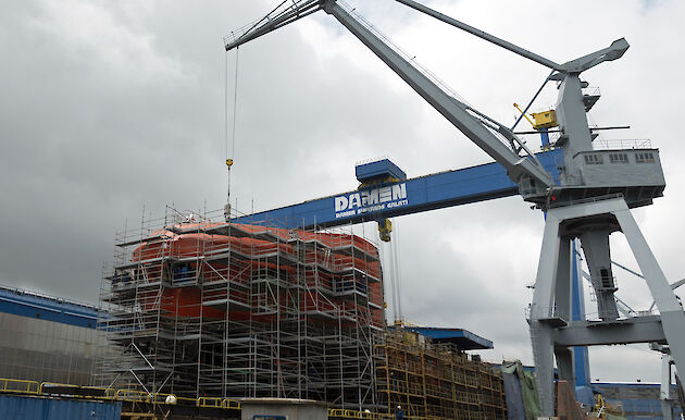 The bow of the ship rising above deck 4 surrounded by scaffolding.