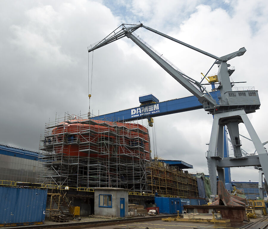 The bow of the ship rising above deck 4 surrounded by scaffolding.