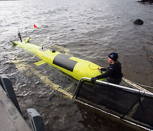 Erica Spain from the Institute for Marine and Antarctic Studies pushes the AUV into the water.