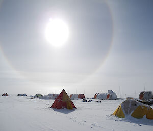 Tents pitched on the Antarctic ice sheet with a solar halo in the sky