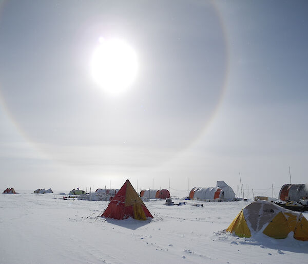 Tents pitched on the Antarctic ice sheet with a solar halo in the sky