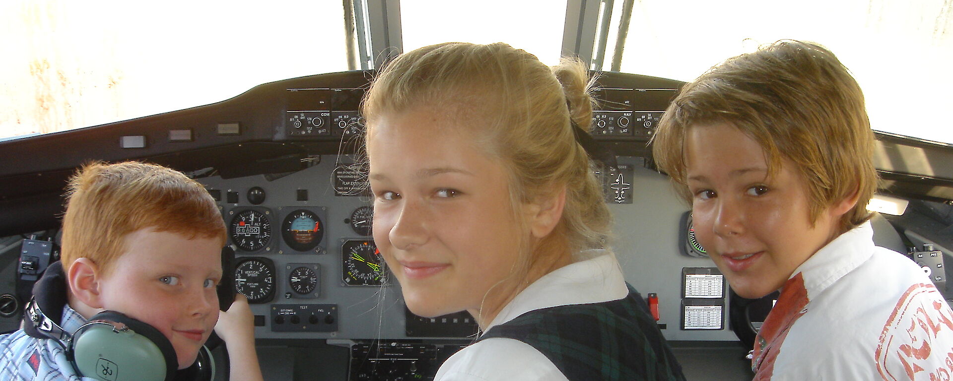 Three children in aeroplane cockpit