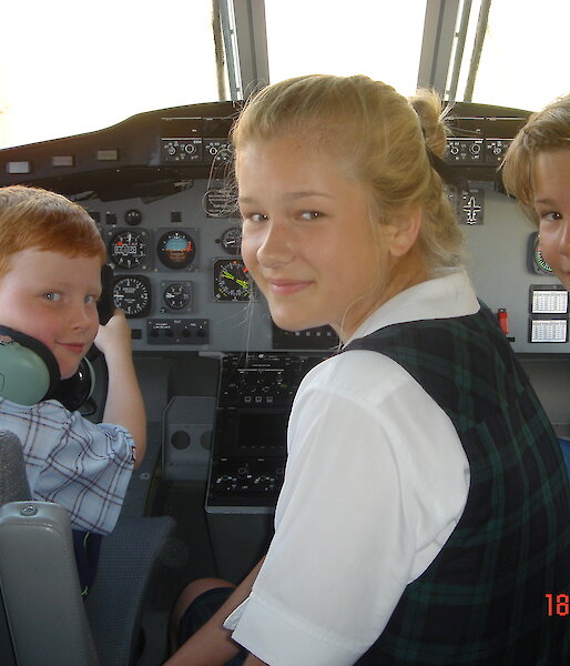 Three children in aeroplane cockpit